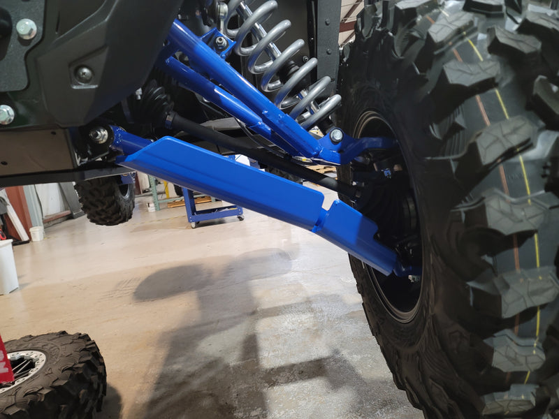 Trail Armor blue iMpact Front Guard installed alongside front suspension on Kawasaki KRX 1000 in shop