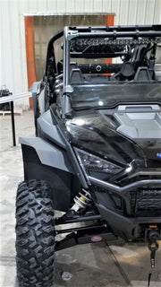 Trail Armor mud flap fender extension installed on the front wheel well of a black Polaris RZR Pro XP 4, viewed near the headlight and A-arm
