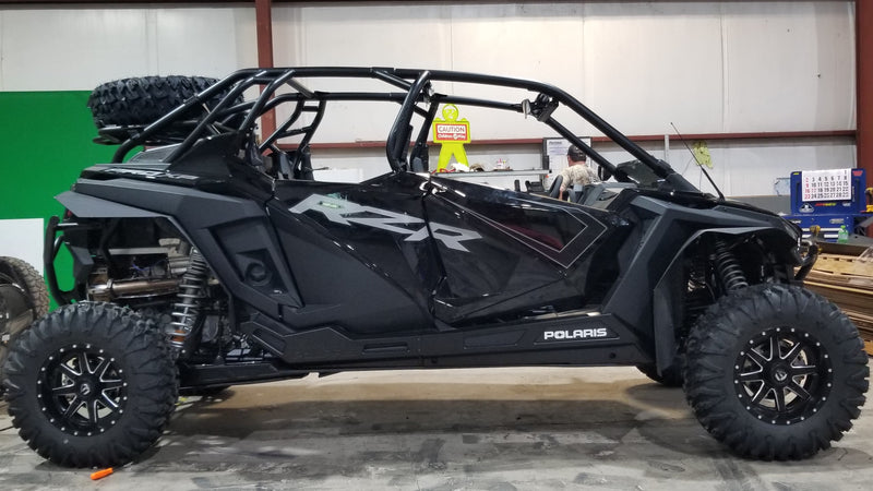 Full side profile of a black four-seat Polaris RZR Pro XP 4 fitted with Trail Armor rocker panel protection
