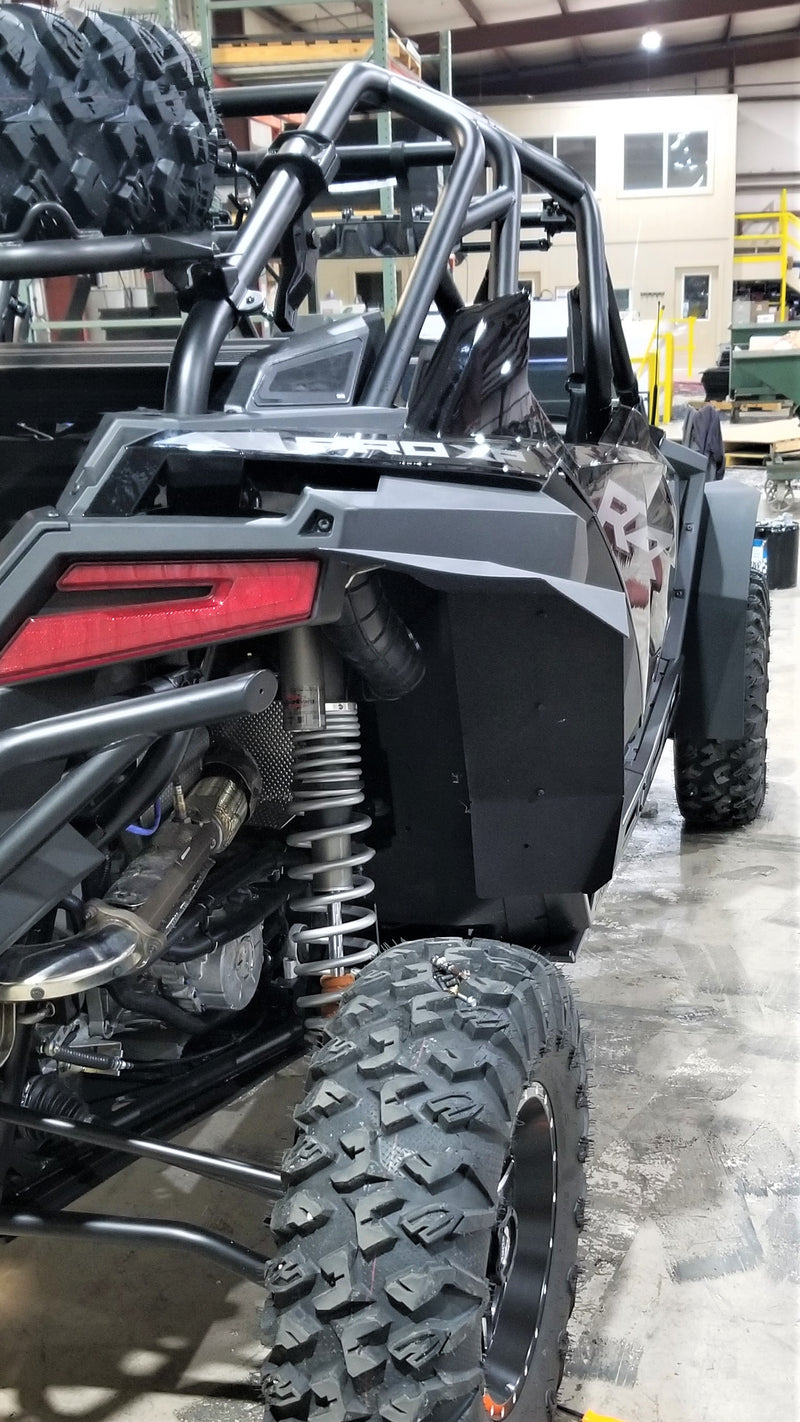 Trail Armor mud flap fender extension installed on the rear wheel well of a Polaris RZR Pro XP 4, shown near the rear shock and taillight