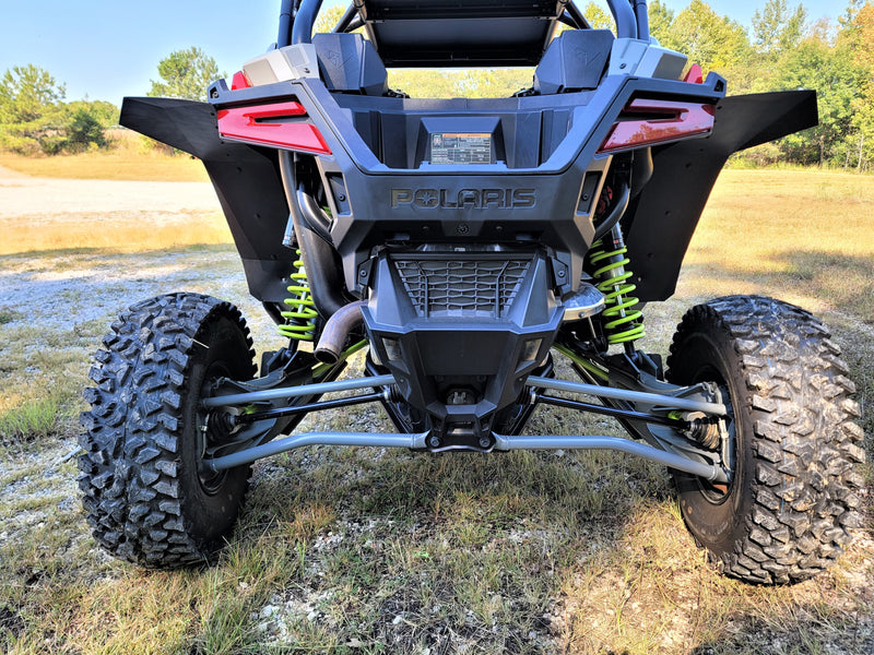 Trail Armor mud flap fender extensions installed on the rear of a Polaris RZR Pro XP, showing full coverage over the wide off-road tires